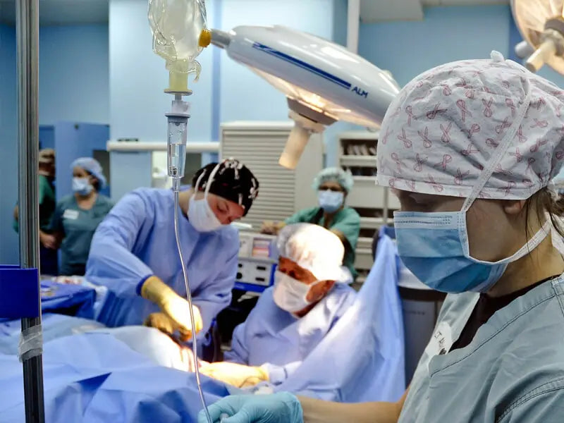 Equipo quirúrgico trabajando en un quirófano con suturas al alcance